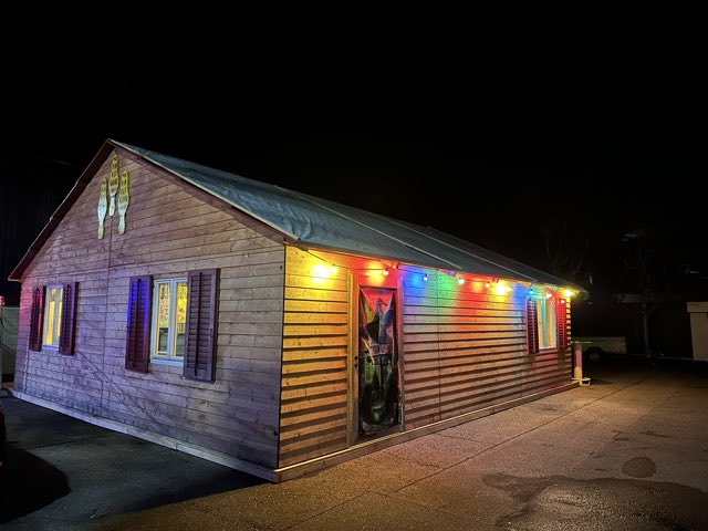 Holzhütte am Häxechessel bei Nacht, farbige Lichterketten dem Dach entlang