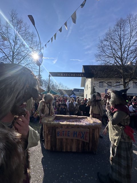Häxe schieben ihren Holzwagen unter dem Schild des Häxechessel hindurch